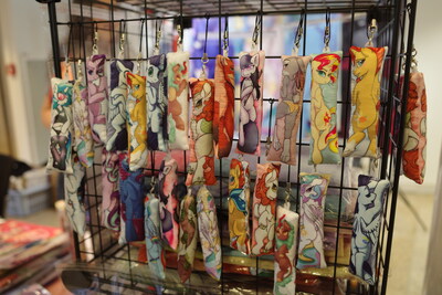 Many vendors had these and similar key fobs. Apparently they suddenly became a thing. I hadn't seen them before. I didn't see any with a picture of a human on it, though. Would be something to give your MLP plushie maybe.