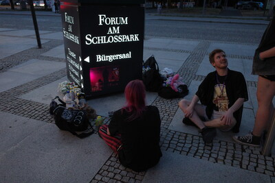 Some visitors watching pony videos projected on a metallic anthracite-coloured surface. That worked very well actually. There is a backstory about this. But I'm not going to tell it in this image description. Maybe I should've put it in the blog post.